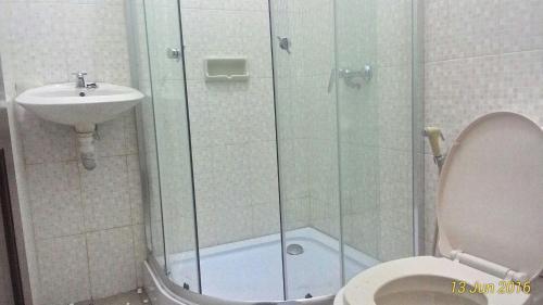 La salle de bains est pourvue d'une douche, de toilettes et d'un lavabo. dans l'établissement Kampoeng Wisata Rumah Joglo, à Bogor