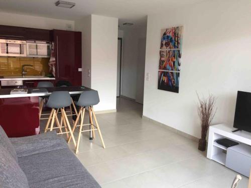 un salon avec un canapé et une cuisine avec une table dans l'établissement Appartement à quelques minutes du lac d’Annecy - Saint-Jorioz, à Saint-Jorioz