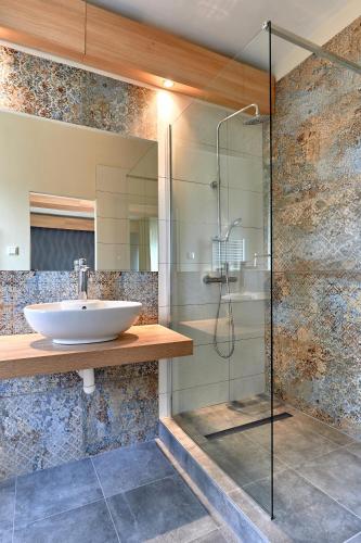 a bathroom with a sink and a glass shower at Hotel Kochau in Kováčová