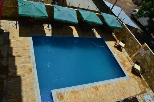 an overhead view of an empty swimming pool with umbrellas at Tiffany Diamond Hotels - Mtwara in Mtwara