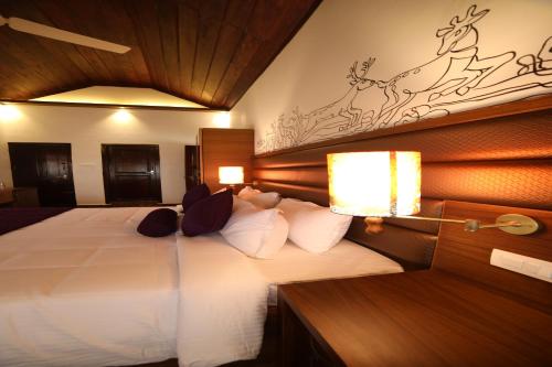 a bedroom with a large bed with white sheets and pillows at CONTOUR ISLAND RESORT & SPA , wayanad in Tariyod