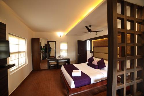 a hotel room with a bed and a desk at CONTOUR ISLAND RESORT & SPA , wayanad in Tariyod