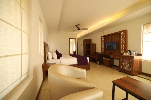 a hotel room with a bed and a living room at CONTOUR ISLAND RESORT & SPA , wayanad in Tariyod