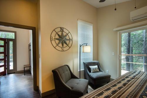 a living room with two chairs and a clock on the wall at 11R Spring Meadow Retreat in Wawona
