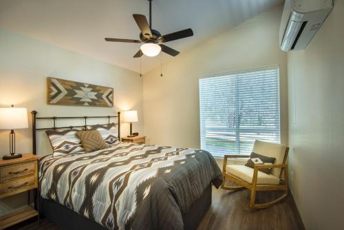 a bedroom with a bed and a fan and a chair at 11R Spring Meadow Retreat in Wawona