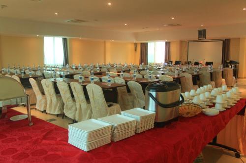 a large banquet hall with a long table with white plates at Tiffany Diamond Hotels - Mtwara in Mtwara