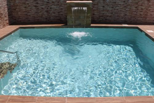 una gran piscina azul con una fuente de agua en Chalet carril de los pareja en Conil de la Frontera