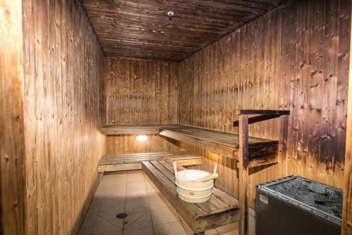 a wooden sauna with a bucket and a sink at One Bedroom Apartment - Pool, Gym & Tennis Courts! in Auckland