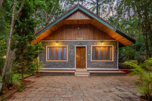 a house in the middle of a forest at Orchid Trails Resort in Sultan Bathery