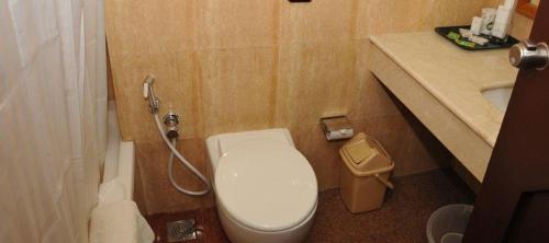 a small bathroom with a toilet and a sink at Presidency Kochi City Centre in Cochin