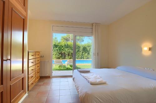 1 dormitorio con 1 cama y puerta corredera de cristal en 5 bedroom house in Begur with private pool and garden (Ref.H53), en Begur