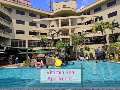 une piscine en face d'un grand bâtiment dans l'établissement 2 mins to beach Apartment 3 rooms, à Kampong Pasir Bogak
