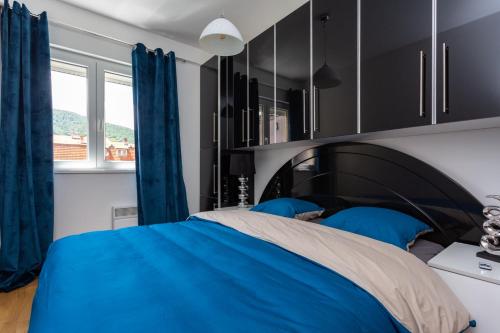 a bedroom with a blue bed and blue curtains at Apartmani Pezerović in Soko Banja