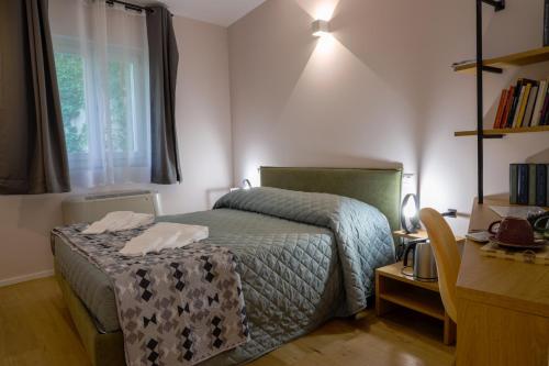 een slaapkamer met een bed, een bureau en een raam bij Bed&Book in Matera