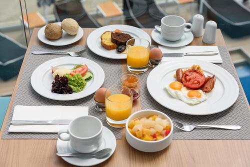 a table topped with plates of breakfast foods and orange juice at Mare Boutique in Georgioupolis
