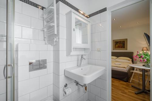 1 dormitorio y baño blanco con lavabo. en Studio - Grandtulipan, en Gdynia