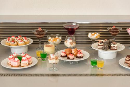a table with several plates of desserts and drinks at Mare Boutique in Georgioupolis