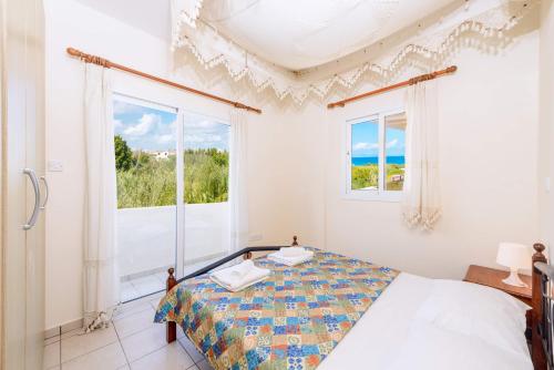 帕拉利米尼的住宿－Villa Di Gio，一间卧室设有一张床和两个窗户。
