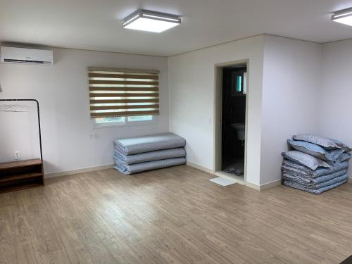 a living room with two blue chairs and a window at Gyeongju Roamers Stay in Gyeongju