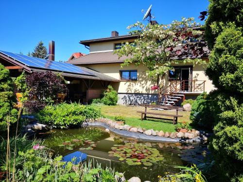 a house with a koi pond in front of it at Jole in Rumšiškės