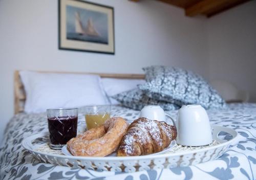 a tray of pastries and drinks on a bed at La finestra sul borgo in Atrani