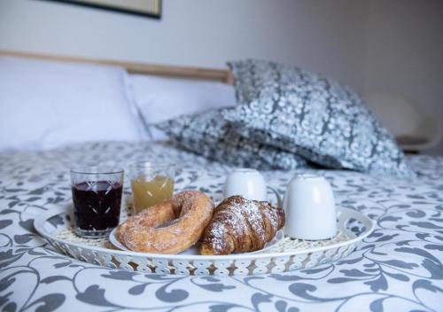 a tray of donuts and a drink on a bed at La finestra sul borgo in Atrani