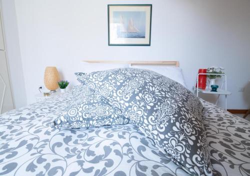 a bed with a blue and white pillow on it at La finestra sul borgo in Atrani