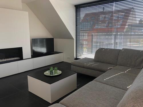 a living room with a couch and a tv at Soetkin in Knokke-Heist