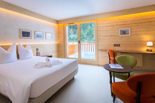 Habitación de hotel con cama grande y escritorio. en Hotel Restaurant Mont Champ du Feu en Belmont