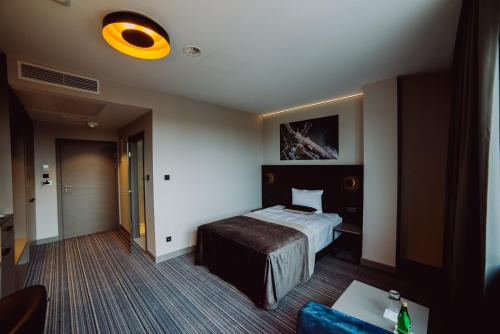 a hotel room with a bed and a yellow light at Hotel Evva in Tarnobrzeg
