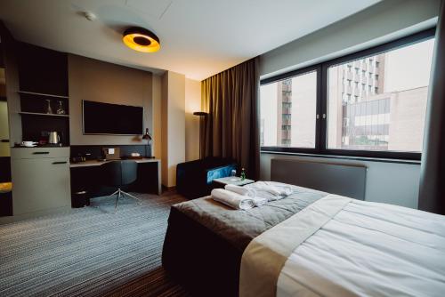 a hotel room with a bed and a large window at Hotel Evva in Tarnobrzeg