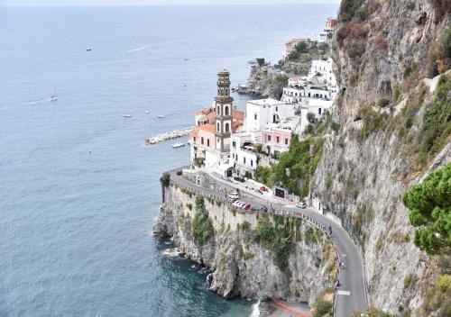 a building on the side of a cliff next to the ocean at La finestra sul borgo in Atrani