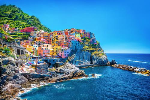 a group of colorful buildings on a cliff next to the ocean at Il Sogno di Manarola by The First in Manarola