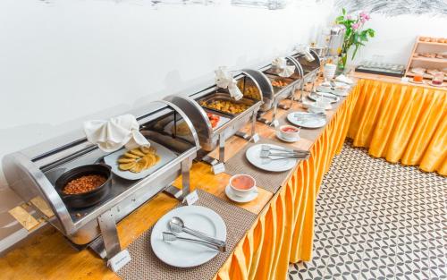 a buffet line with plates of food on a table at Home Chic Hotel in Phnom Penh