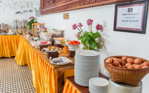 a long table with plates and eggs on it at Home Chic Hotel in Phnom Penh