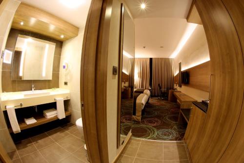 ガジアンテプにあるDedeman Park Gaziantep City Centerのバスルーム(トイレ、洗面台、鏡付)