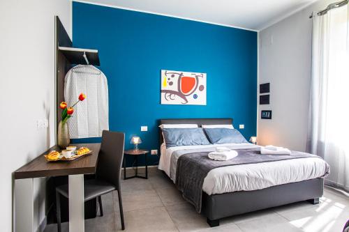 a bedroom with a blue wall and a bed and a table at Garibaldi 136 in Naples