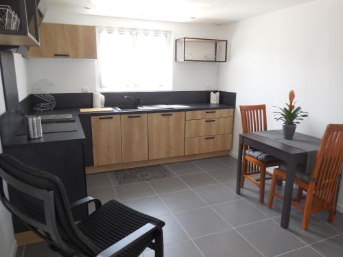 une cuisine avec une table et des chaises ainsi qu'une salle à manger dans l'établissement location terre mer, à Le Temple