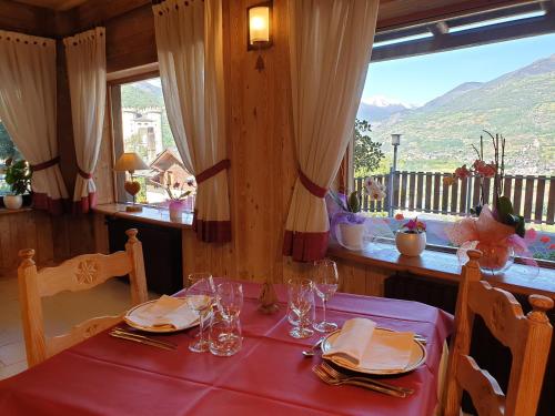 a dining room with a table with a red table cloth at Hotel Rendez-Vous - Aymavilles in Aymavilles