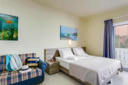 a hotel room with a bed and a couch at Eden Beach Hotel in Agia Marina Nea Kydonias