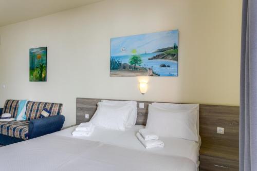a hotel room with a bed and a chair at Eden Beach Hotel in Agia Marina Nea Kydonias