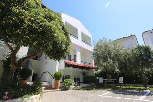 a white building with a table in a parking lot at Elia in Skála Foúrkas