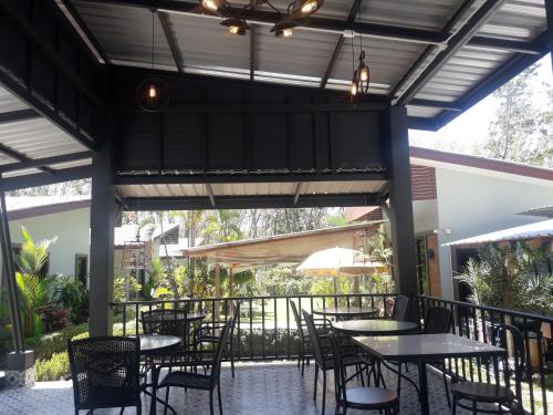 een patio met tafels en stoelen op een balkon bij Phuket Sirinapha Resort in Nai Yang Beach
