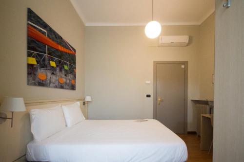 a bedroom with a white bed and a painting on the wall at Best Quality Hotel Dock Milano in Turin