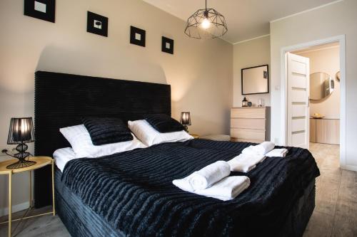 1 dormitorio con 1 cama grande y toallas. en Apartamenty Silence Baltic Classic en Pobierowo