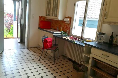a kitchen with a counter and a red bag on a chair at Villa Beckmann in Gengenbach