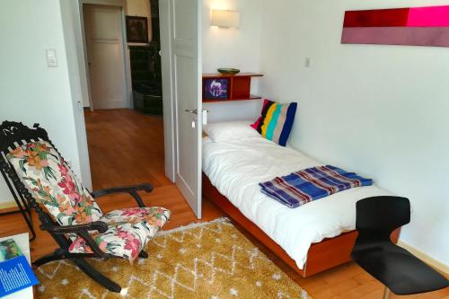 a small room with a bed and a chair at Villa Beckmann in Gengenbach