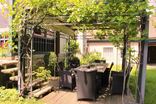 a pergola with a table and chairs under it at Villa Beckmann in Gengenbach