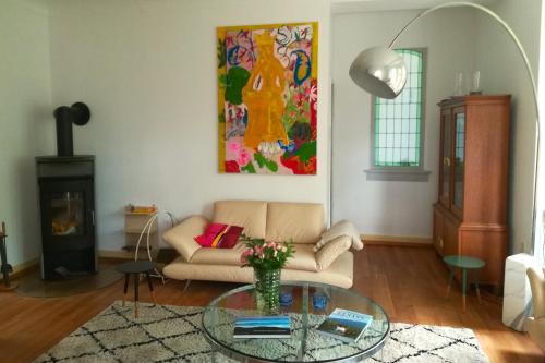 a living room with a couch and a glass table at Villa Beckmann in Gengenbach
