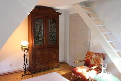 a room with a staircase and a wooden cabinet at Villa Beckmann in Gengenbach